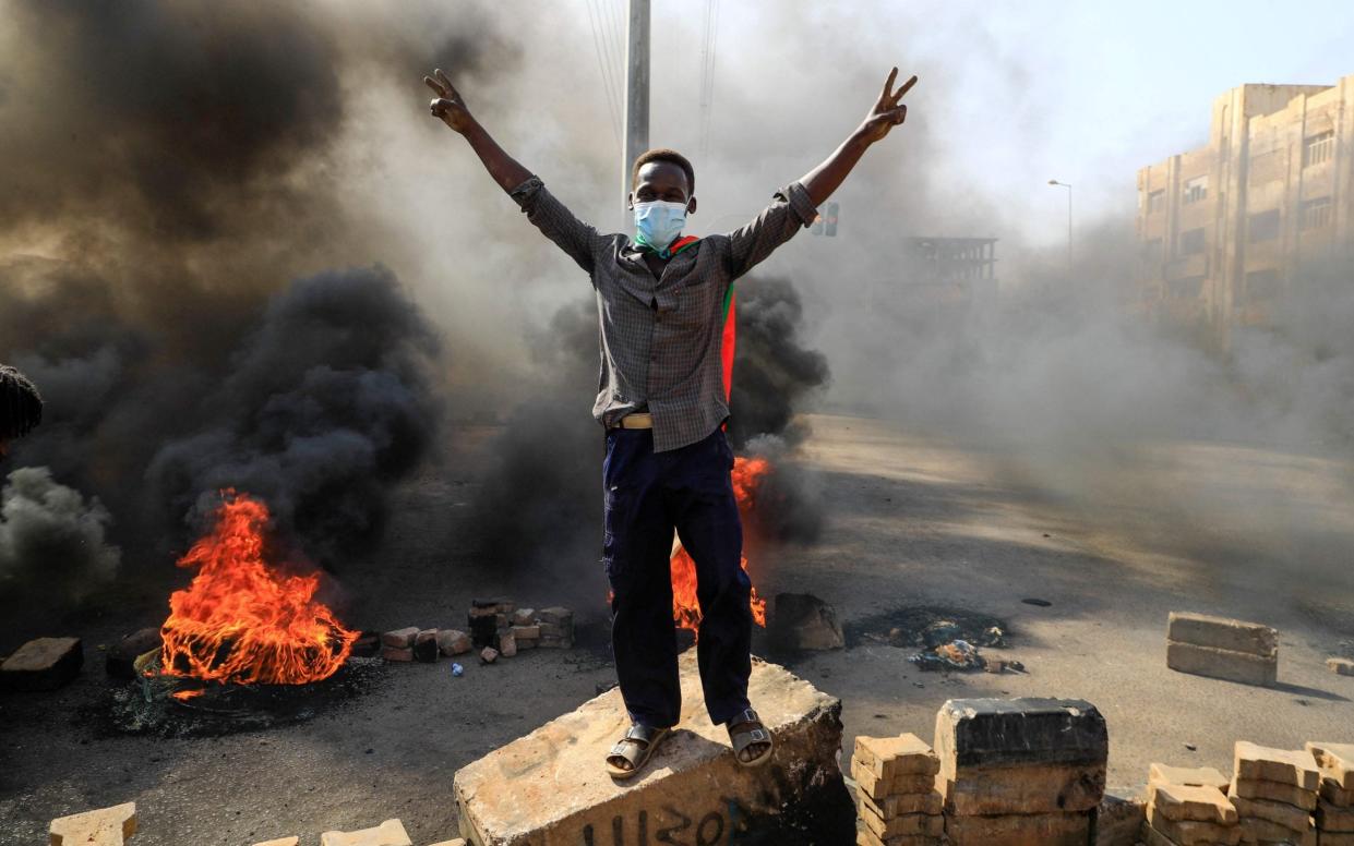 Sudanese protesters burn tyres to block a road in 60th Street in the capital Khartoum, to denounce overnight detentions by the army of members of Sudan's government - AFP