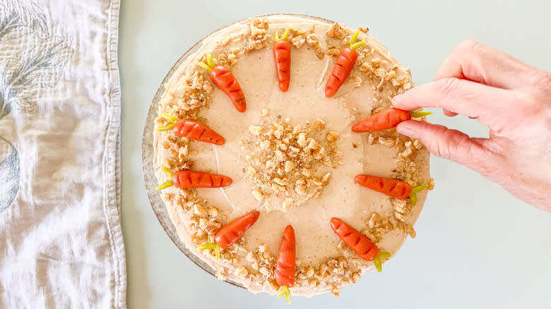 Marzipan carrots on top of vegan carrot cake with cinnamon-cashew frosting