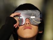 PALM COVE, AUSTRALIA - NOVEMBER 14: A spectator views the solar eclipse through special eclipse viewing glasses on November 14, 2012 in Palm Cove, Australia. Thousands of eclipse-watchers have gathered in part of North Queensland to enjoy the solar eclipse, the first in Australia in a decade. (Photo by Ian Hitchcock/Getty Images)