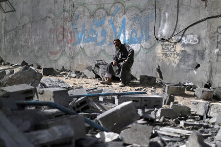 A Palestinian man sits on debris near a building that was destroyed by Israeli air strikes, in Gaza City May 6, 2019. REUTERS/Mohammed Salem