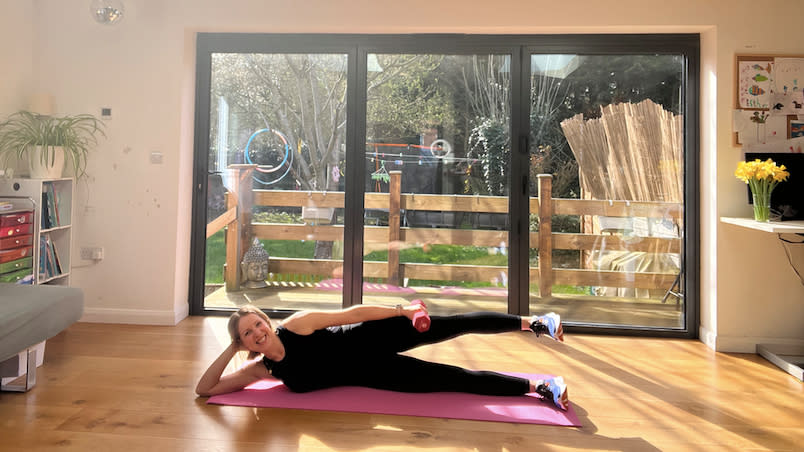 Maddy Biddulph performing a weighted side-lying leg raise