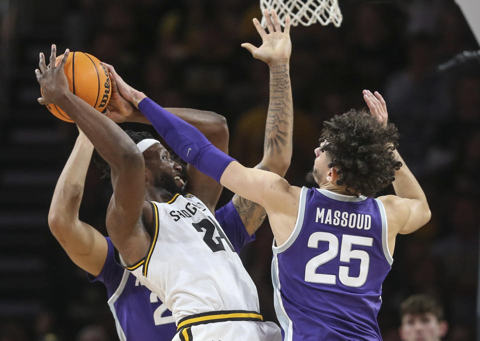 Wichita State forward Morris Udeze, center, is defended by Kansas State's Ismael Massoud, right, Davion Bradford, left, during the first half of an NCAA college basketball game Sunday, Dec. 5, 2021, in Wichita, Kan. (Travis Heying/The Wichita Eagle via AP)