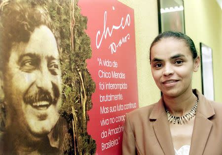 Brazilian then-Senator Marina Silva poses beside a poster of the late-environmentalist Chico Mendes in Brasilia in this December 11, 2002 file photo. REUTERS/Jamil Bittar/Files