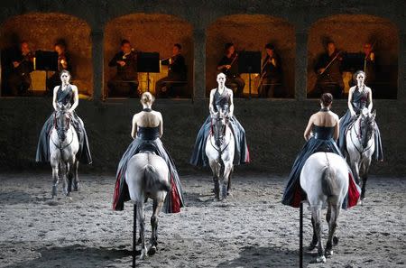 Horses and riders perform on stage during a dress rehearsal of Wolfgang Amadeus Mozart's cantata "Davide penitente" in Salzburg January 20, 2015. REUTERS/Dominic Ebenbichler