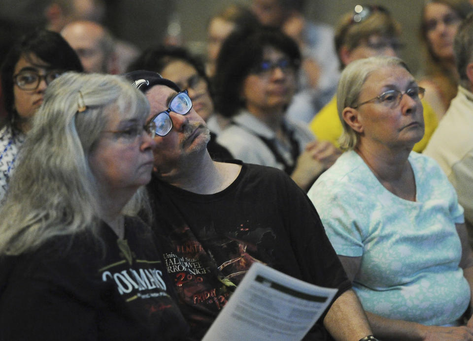 Residents listen during a community meeting at an auditorium in Yosemite Valley to share the latest information about the Ferguson Fire Tuesday, July 24, 2018, in Yosemite National Park, Calif. A Yosemite National Park official says at least a thousand campground and hotel reservations will be canceled after authorities decided to close Yosemite Valley to keep a growing forest fire at bay. Spokesman Scott Gediman says the valley, the heart of the visitor experience at the park, along with a windy, mountainous, 20-mile (32-kilometer) stretch of State Route 41 that is part of Yosemite will close beginning Wednesday at noon. (Eric Paul Zamora/The Fresno Bee via AP)