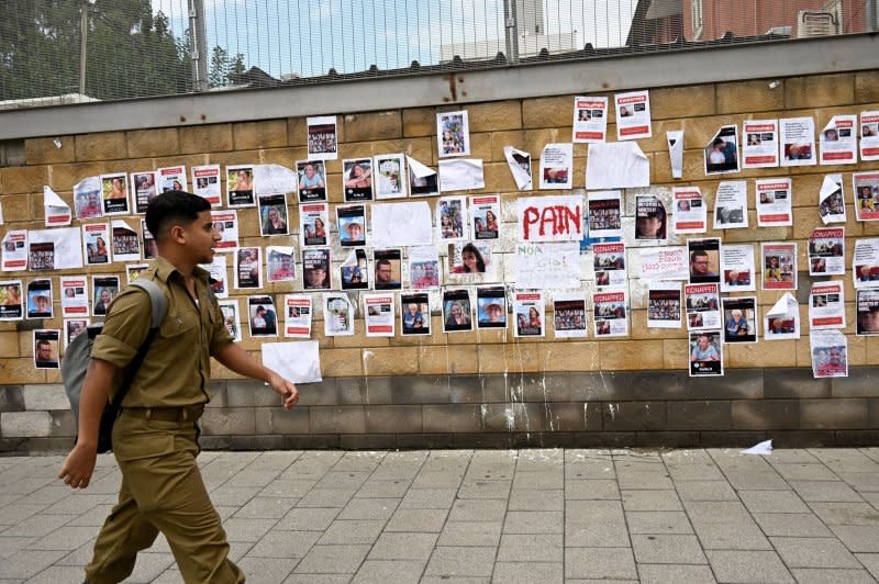 An Israeli soldier looks at fliers of hostages on the wall outside the Israel Defense Headquarters earlier this month. Over 1,300 Israelis were killed Oct. 7 when Hamas breached the wall between Gaza and Israel, also taking over 100 Israelis, as well as foreign nationals, hostage. Photo by Debbie Hill/UPI