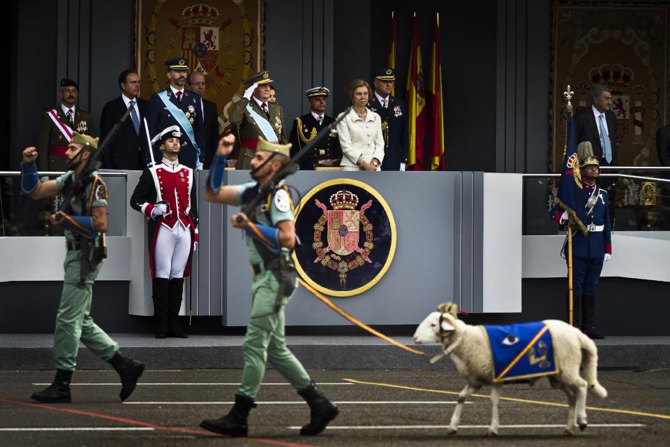 A goat, the mascot of La Legion, an elite unit of the Spanish Army, marches in front of the tribune where Spain's Crown Prince Felipe, left, Spain's King Juan Carlos, center, and Queen Sofia attend a military parade, during the holiday known as Dia de la Hispanidad, Spain's National Day, in Madrid, Friday, Oct. 12, 2012. King Juan Carlos presided over a much reduced parade that featured none of the usual fighter jets or tanks as they celebrate the day Christopher Columbus discovered America in the name of the Spanish Crown.(AP Photo/Daniel Ochoa de Olza)