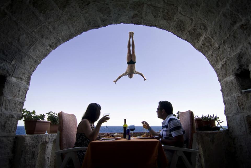 <div class="inline-image__caption"><p>An Italian couple sits during lunch as Steve Black of Australia dives past their balcony in the lead up round four of the 2010 Red Bull Cliff Diving world series in Polignano a Mare August 5, 2010. </p></div> <div class="inline-image__credit">Dean Treml/Red Bull Photofiles/Reuters</div>