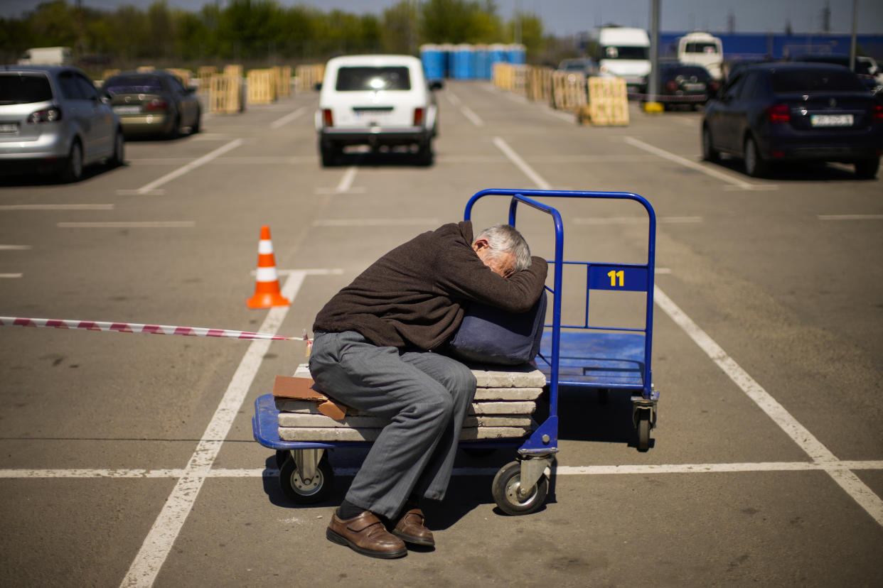 FILE - A man who fled from a small village near Polohy rests upon his arrival to a reception center for displaced people in Zaporizhzhia, Ukraine, on May 8, 2022. Thousands of Ukrainian continue to leave Russian occupied areas. According to Russian state TV, the future of the Ukrainian regions occupied by Moscow's forces is all but decided: Referendums on becoming part of Russia will soon take place there, and the joyful residents who were abandoned by Kyiv will be able to prosper in peace. In reality, the Kremlin appears to be in no rush to seal the deal on Ukraine's southern regions of Kherson and Zaporizhzhia and the eastern provinces of Donetsk and Luhansk. (AP Photo/Francisco Seco)