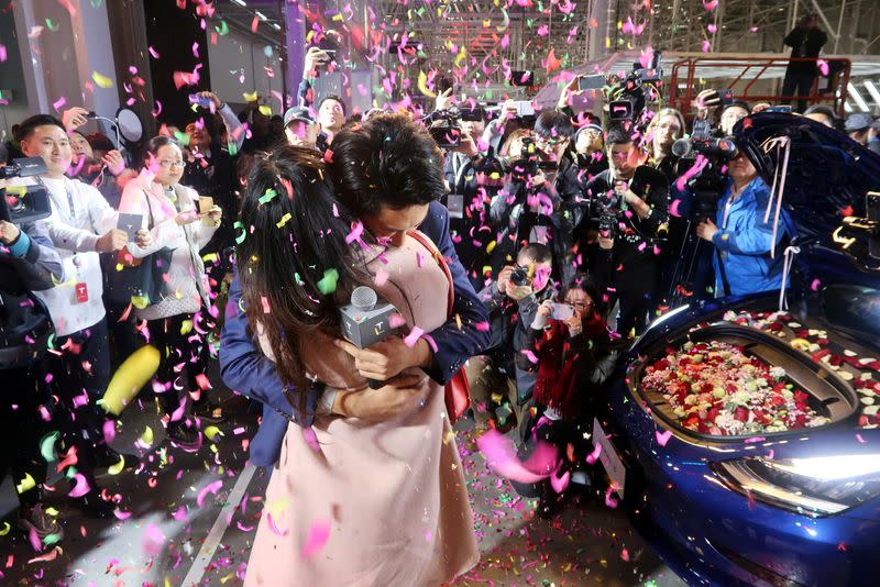 Tesla employee proposes to his girlfriend with a China-made Tesla Model 3 vehicle filled with flowers at a delivery ceremony in the Shanghai Gigafactory of the U.S. electric car maker in Shanghai