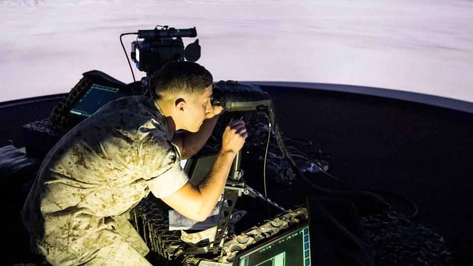 A squad leader calculates distance and elevation of a simulated target during emergency close-air support training at the Supporting Arms Virtual Trainer facility aboard Camp Lejeune, N.C., in 2015. (Cpl. Shawn Valosin/U.S. Marine Corps)