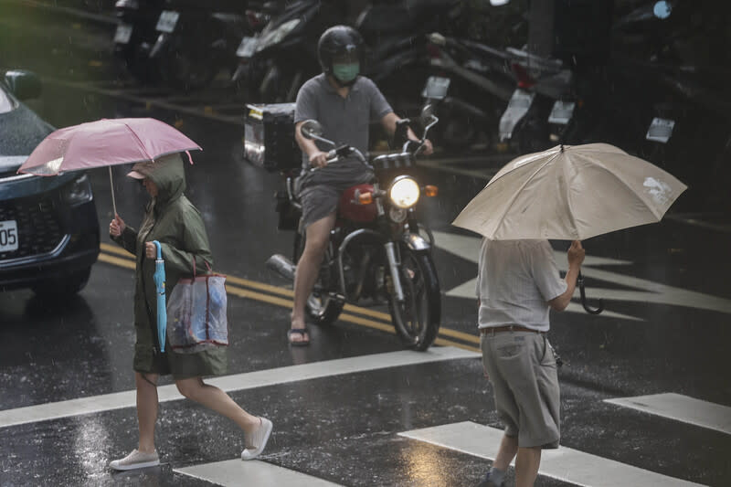 北北基桃大雨特報（2） 對流雲系發展旺盛，易有短延時強降雨，交通部中央 氣象署21日下午發布10縣市大雨特報。台北市松山區 下午下起大雨，路上行人快步過馬路。 中央社記者裴禛攝  113年6月21日 