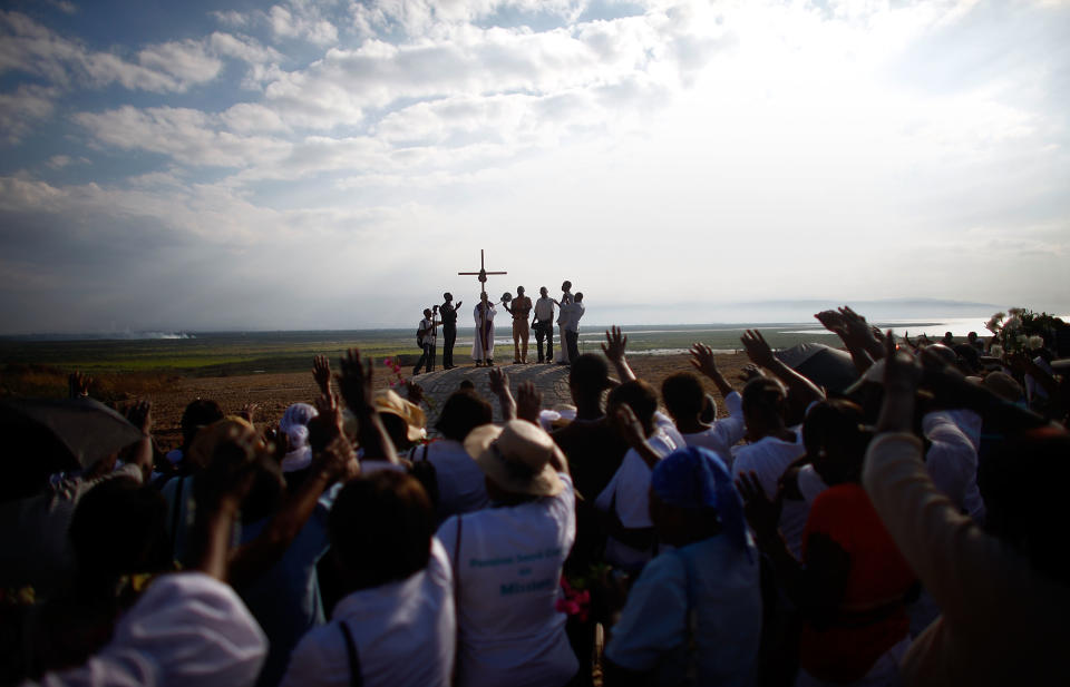 Parishioners from the Saint Louis King of France Catholic church in Port-au-Prince sing and cry as they dedicate a monument they built on the site of the mass graves of those who died in the 2010 earthquake. More than 25,000 people were killed.