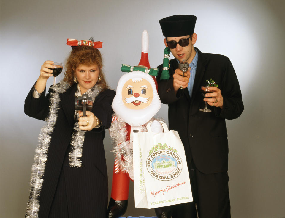 Singers Kirsty MacColl (1959 - 2000) and Shane MacGowan with with toy guns and an inflatable Santa in a festive scenario, circa 1987. In 1987, the pair collaborated on the Pogues&#39; Christmas song &#39;Fairytale of New York&#39;. (Photo by Tim Roney/Getty Images)