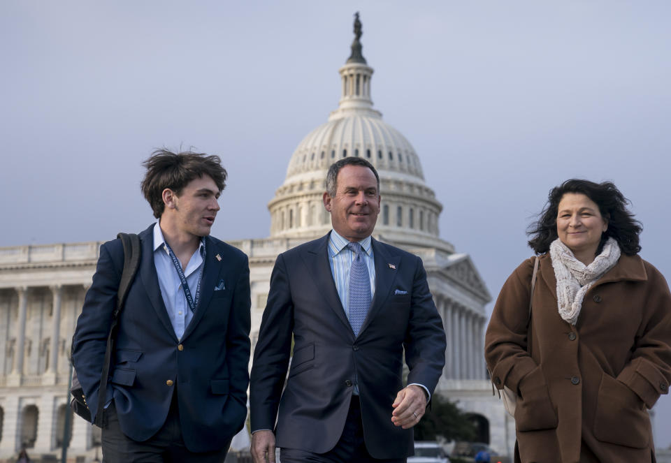 Adam Frisch of Aspen, Colo., center, the Democrat who opposed Rep. Lauren Boebert, R-Colo., in Colorado's 3rd Congressional District, walks with his son Felix Frisch, left, and wife Katy Frisch, right, at the Capitol in Washington, Friday, Nov. 18, 2022. (AP Photo/J. Scott Applewhite)