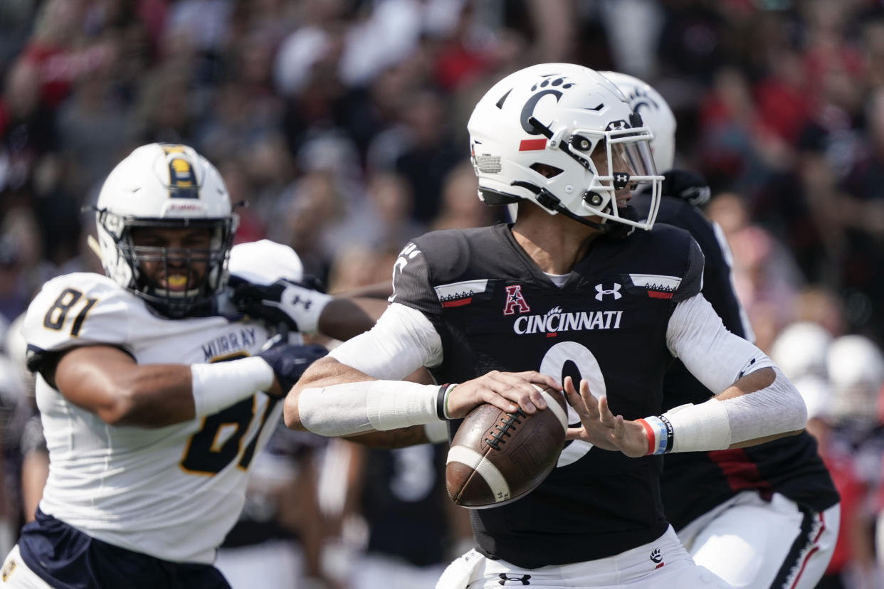 Cincinnati quarterback Desmond Ridder, center, drops back for a pass during the first half of an NCAA college football game against Murray State Saturday, Sept. 11, 2021, in Cincinnati. (AP Photo/Jeff Dean)