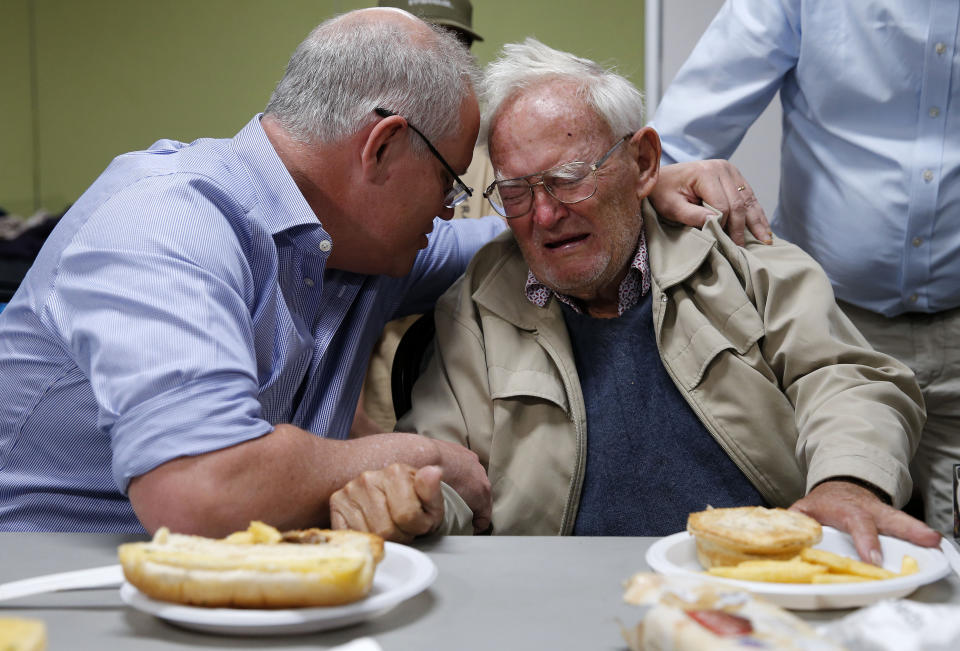 Prime Minister Scott Morrison comforts 85-year-old bushfire evacuee Owen Whalan of Half Chain road in Koorainghat at Club Taree Evacuation Centre in Taree, New South Wales on Sunday. Source: AAP