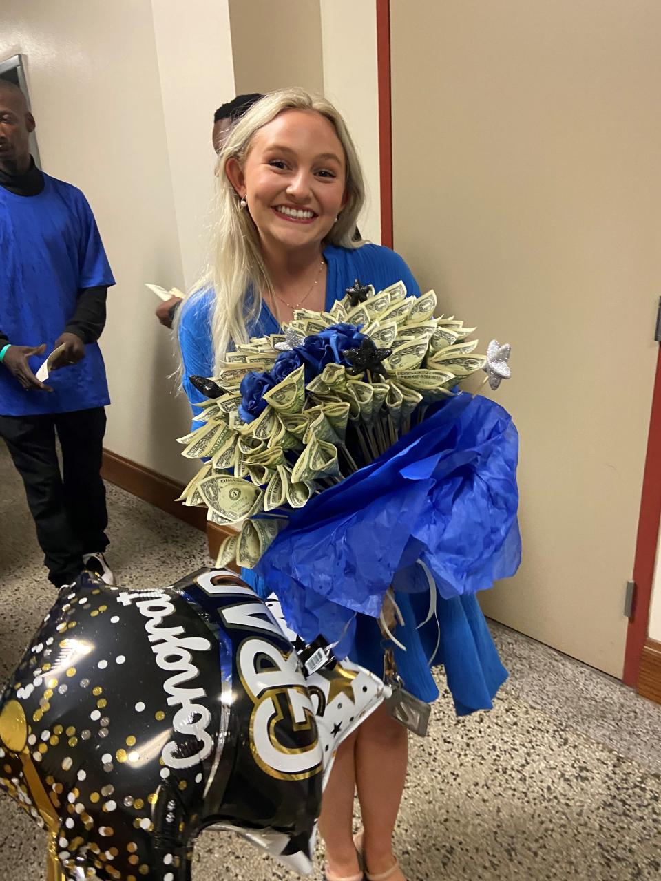 McKenzie Juneau holds a balloon and money bouquet for her boyfriend's sister, Claina Henry, who graduated Monday from Bolton High School.