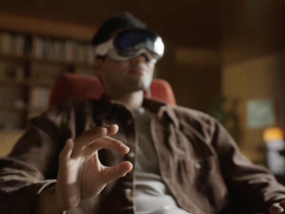 Man seated using an Apple Vision Pro headset.