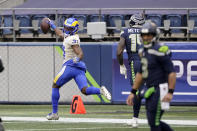 Los Angeles Rams defensive back Darious Williams (31) looks back as he scores on an interception from Seattle Seahawks quarterback Russell Wilson, right, during the first half of an NFL wild-card playoff football game, Saturday, Jan. 9, 2021, in Seattle. (AP Photo/Ted S. Warren)