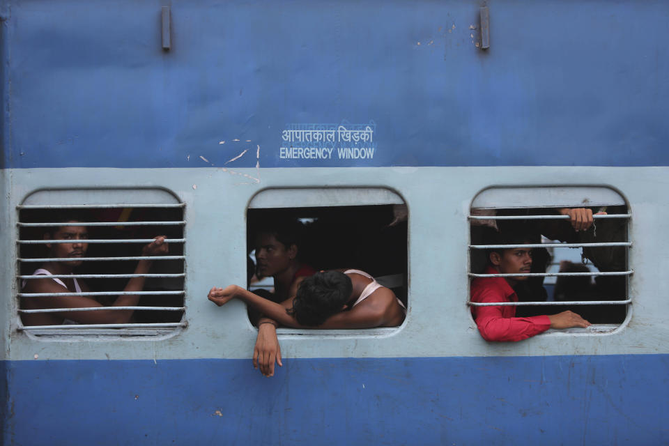 Indian migrant laborers sit inside a train as they prepare to leave the region, at a railway station in Jammu, India, Wednesday, Aug. 7, 2019. Indian lawmakers passed a bill Tuesday that strips statehood from the Indian-administered portion of Muslim-majority Kashmir, which remains under an indefinite security lockdown, actions that archrival Pakistan warned could lead to war. (AP Photo/Channi Anand)