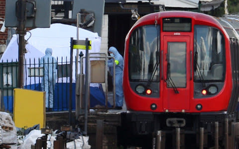 Forensic investigators search on the platform at Parsons Green tube station  - Credit: HANNAH MCKAY /REUTERS