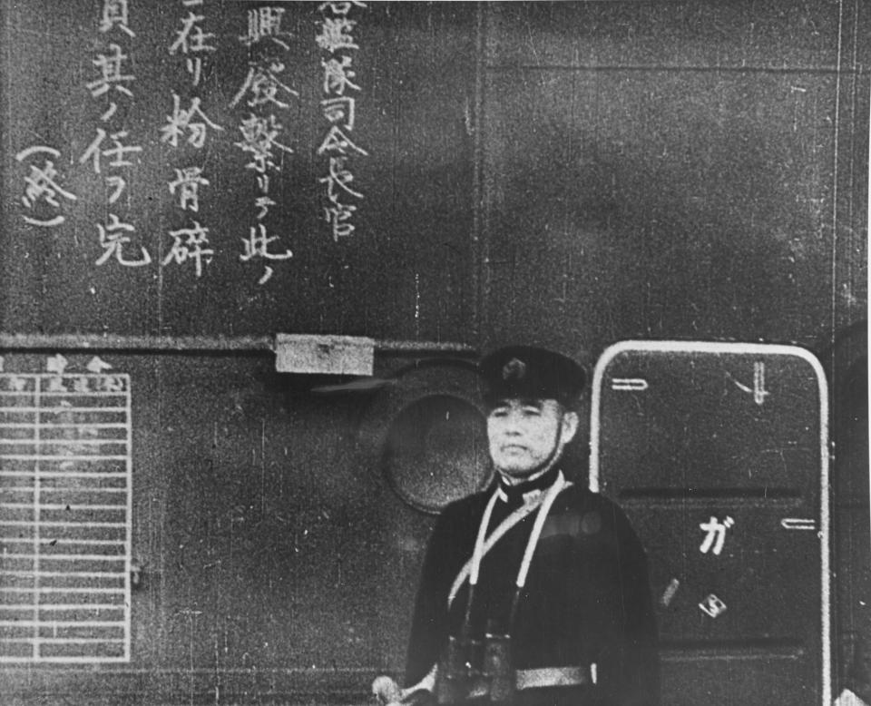 <p>An officer on the Japanese aircraft carrier Shokaku watches as planes take off to attack Pearl Harbor on Dec. 7, 1941. The Kanji inscription at left is a commander order to pilots to do their duty to destroy the enemy. (U.S. Navy/National Archives/Handout via Reuters) </p>