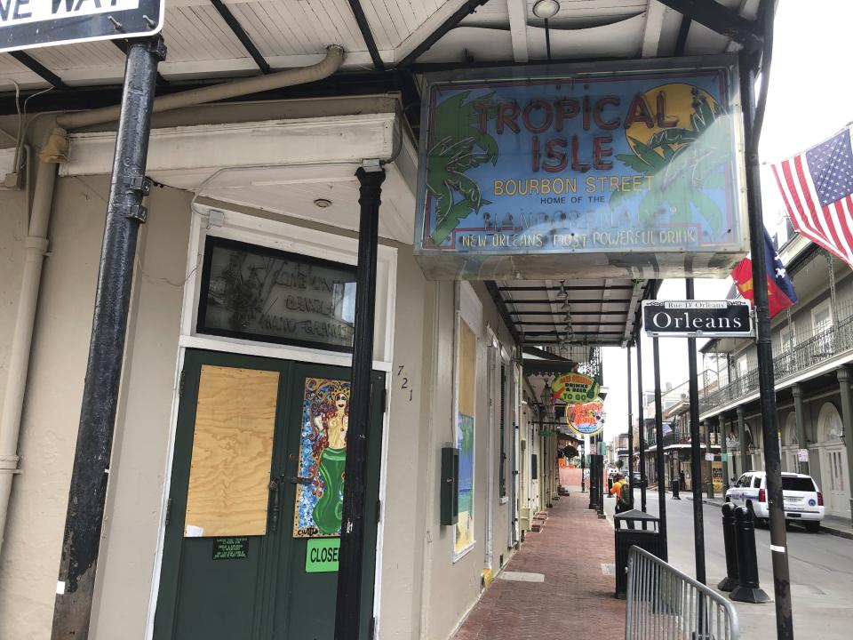 In this Wednesday, May 20, 2020, a bar is boarded-up at a Bourbon Street intersection in New Orleans’ French Quarter. Bars have been closed in New Orleans since early March because of the coronavirus pandemic. Some residents of the historic French Quarter, while acknowledging the economic pain and suffering, say the lack of tourists has been a relief. (AP Photo/Kevin McGill)