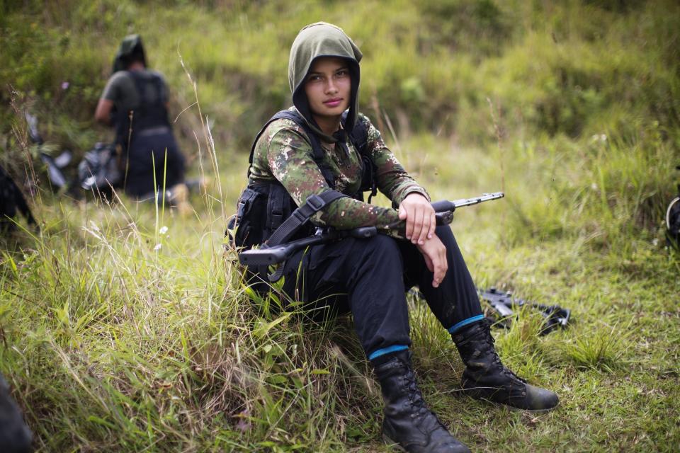 FILE - In this Jan. 6, 2016 file photo, Juliana, a 20-year-old rebel fighter for the 36th Front of the Revolutionary Armed Forces of Colombia, or FARC, rests from a trek in the northwest Andes of Colombia, in Antioquia state. The top peace negotiator for the FARC announced Thursday, Aug. 29, 2019, that he and a cadre of hardline supporters are taking up arms again, accusing President Ivan Duque of failing to uphold the accord that sought to end a half century of bloody fighting. (AP Photo/Rodrigo Abd, File)