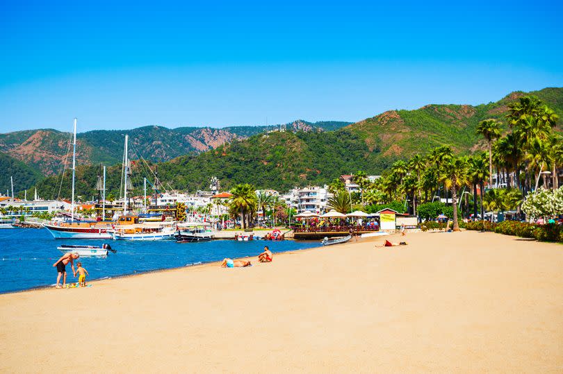 Marmaris beach with hills and boats in the background