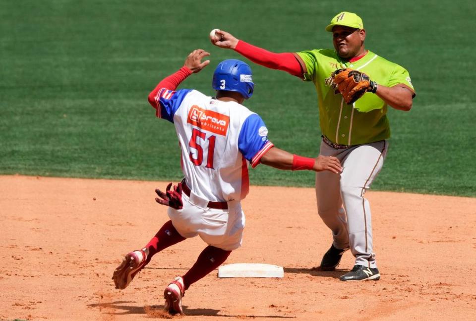 El segunda base cubano Carlos Benítez completa una jugada de doble matanza tras poner out al bateador designado de Puerto Rico Rubén Castro, en el partido de la Serie del Caribe celebrado el 7 de febrero de 2023 en Caracas, Venezuela.