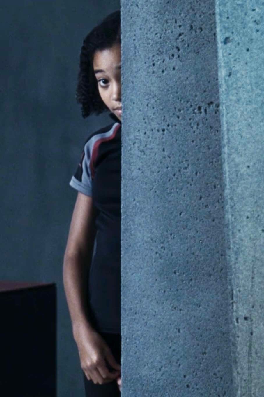 Rue peeking from behind a wall with a cautious expression