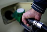 A man fills up his car at a petrol station in Rome