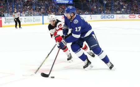 Nov 25, 2018; Tampa, FL, USA; Tampa Bay Lightning left wing Alex Killorn (17) skates with he puck as New Jersey Devils center Travis Zajac (19) defends during the first period at Amalie Arena. Mandatory Credit: Kim Klement-USA TODAY Sports