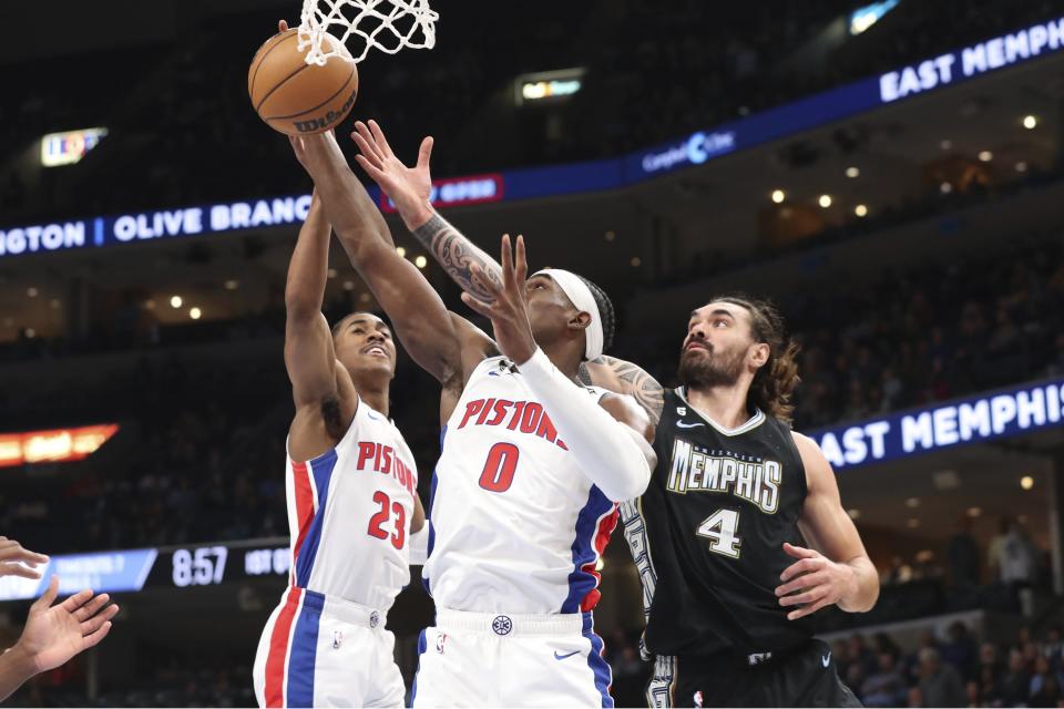 Pistons guard Jaden Ivey, left, and center Jalen Duren grab a rebound from Grizzlies center Steven Adams during the first half of the Pistons' 114-103 loss on Friday, Dec. 9, 2022, in Memphis, Tennessee.