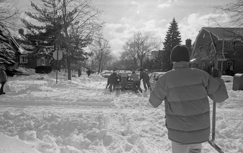 blizzard of 1978 nyc, people pushing a stranded vehicle