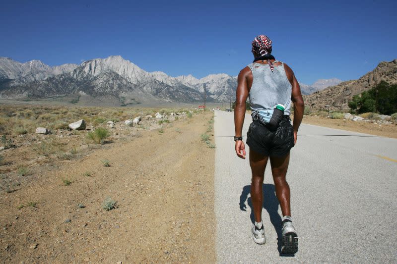 Lone Pine, ESTADOS UNIDOS: El competidor David Goggins, de 31 años, antiguo miembro de la Marina de los Estados Unidos, se enfrenta a Mt. Whitney y a las últimas 13 millas (21 km) de la Ultramaratón Badwater de 135 millas (217 kilómetros), el 25 de julio de 2006, en Lone Pine, California. Esta carrera a pie comprende 135 millas (217kms) sin parar desde la cuenca Badwater, la elevación más baja del hemisferio occidental a 282 pies (85.5 metros) debajo del nivel del mar, hasta el monte Mt. Whitney Portals a 8 360 pies (2 533 metros) sobre el nivel del mar. La temperatura en Death Valley alcanza los 126 °F (52 °C) y hay que cruzar tres cadenas montañosas, lo que convierte a esta carrera en una de las más exigentes y extremas del mundo. AFP PHOTO/ROBYN BECK (El crédito de la foto debería decir ROBYN BECK / AFP vía Getty Images)