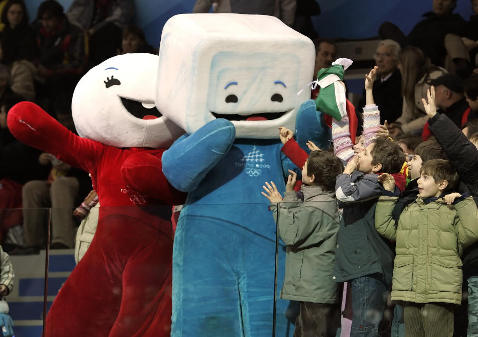 Children attending the short track skating races in the Palavela Arena cheer with Torino Olympic mascots Neve, left and Gliz at the 2006 Winter Olympics in Turin, Italy, Feb. 15, 2006. (AP Photo/Amy Sancetta)