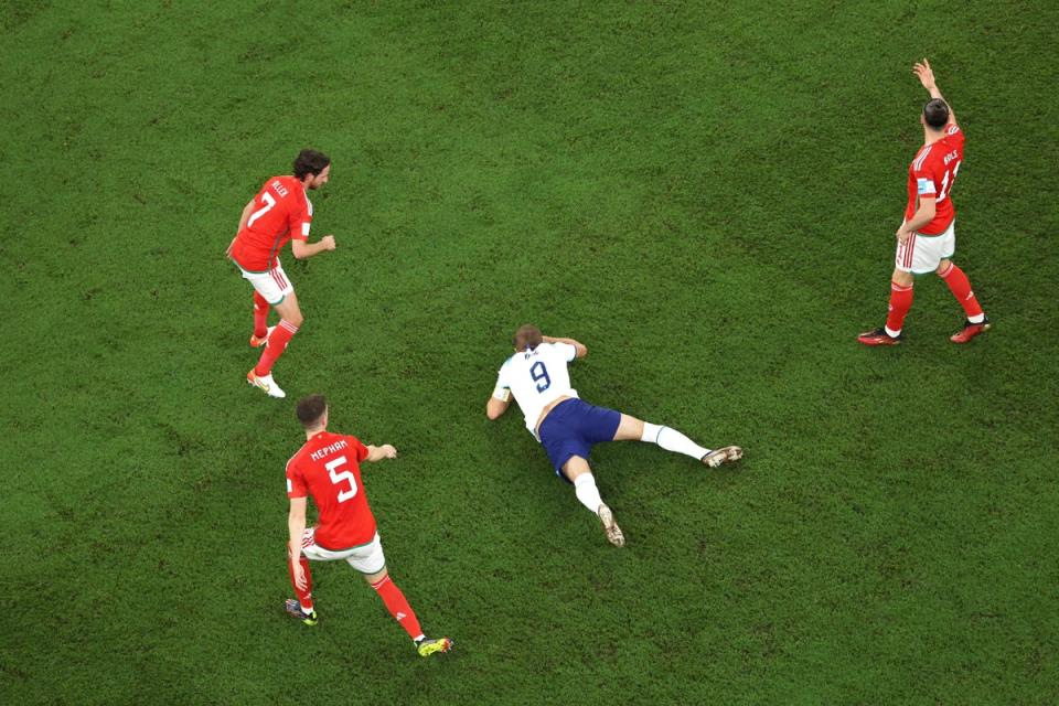 Harry Kane on the floor surrounded by Wales players (Getty)