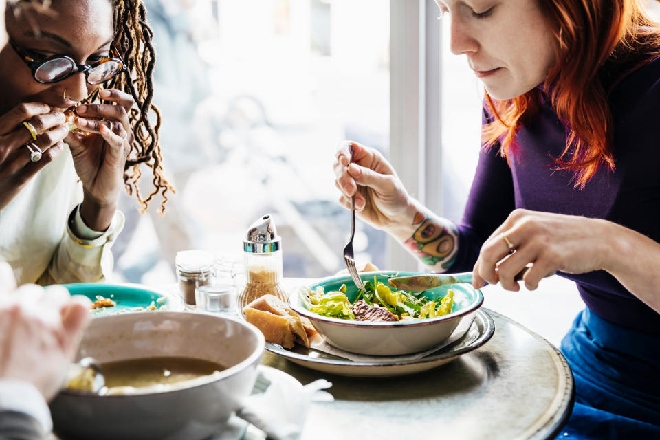 Two women sitting in a cafe enjoying a vegan meal. (Getty Images)