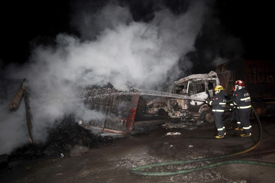 In this photo released by Xinhua News Agency, firefighters try to extinguish burning vehicles in the aftermath of an explosion at a plant operated by the Hebei Shenghua Chemical Industry Co. Ltd Wednesday, Nov. 28, 2018 in Zhangjiakou city, northeastern China's Hebei province. The explosion early Wednesday outside the chemical plant in northeastern China has killed people and destroyed scores of vehicles. (Xinhua via AP)