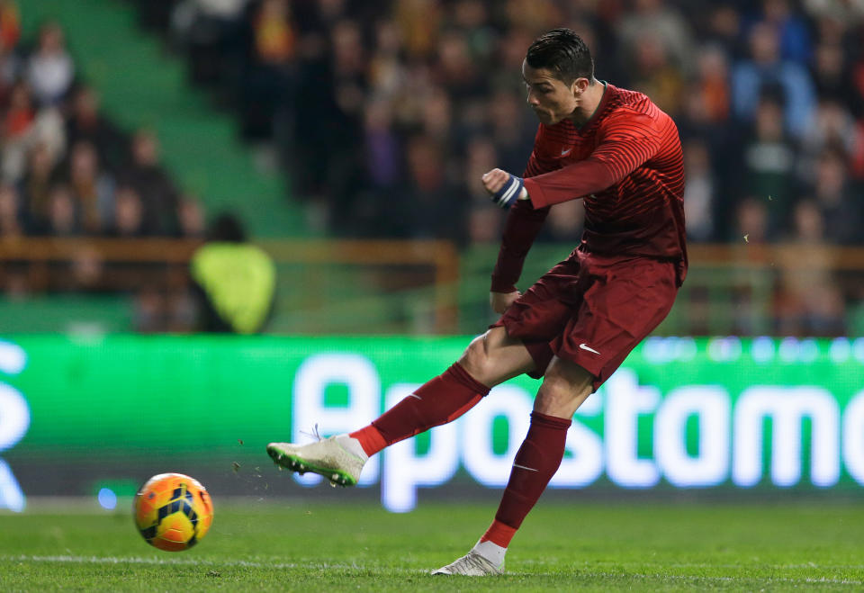 Portugal's Cristiano Ronaldo shoots to score the opening goal during their friendly soccer match with Cameroon Wednesday, March 5 2014, in Leiria, Portugal. The game is part of both teams' preparation for the World Cup in Brazil. (AP Photo/Armando Franca)