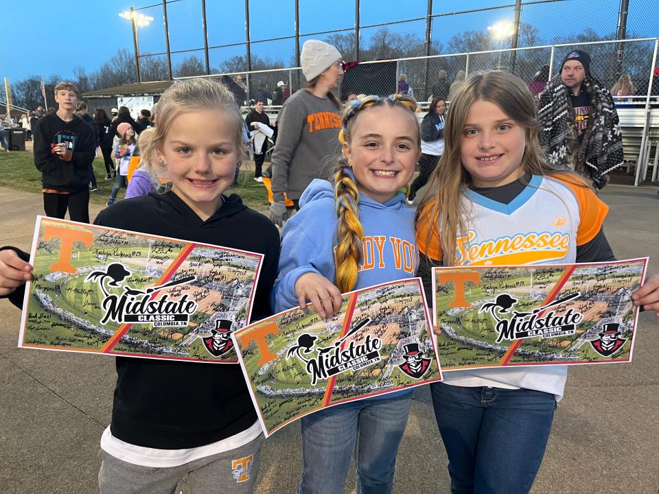 Tennessee Elite softball team members Brinley Carlton, Shayla Anast and Brylee Rofrano, all 8, hold the signed team poster for the Midstate Classic with the University of Tennessee Lady Volunteers facing off against the Austin Peay State University Lady Governors.