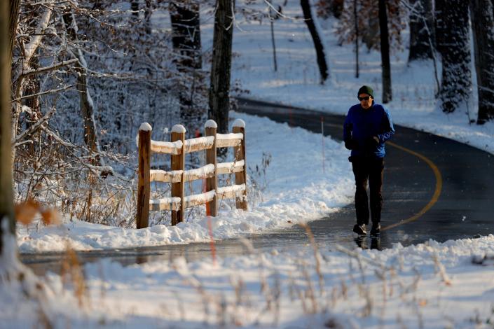 John Salvette, 66 of Ann Arbor gets in his morning run among the fresh snow at Kensington Metropark in Milford on Tuesday Nov, 30, 2021.