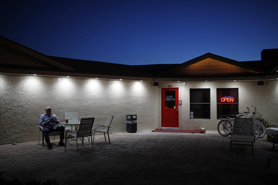 File - In this April 27, 2018, file photo, owner Dennis Hof sits in front of the Love Ranch brothel in Crystal, Nev. An autopsy says Hof, America's most famous pimp, died of a heart attack in bed at one of his legal brothels in rural Nevada after a weekend-long 72nd birthday bash more than five months ago, the Nye County Sheriff Sharon Wehrly's office announced Thursday, March 29, 2019. (AP Photo/John Locher, File)