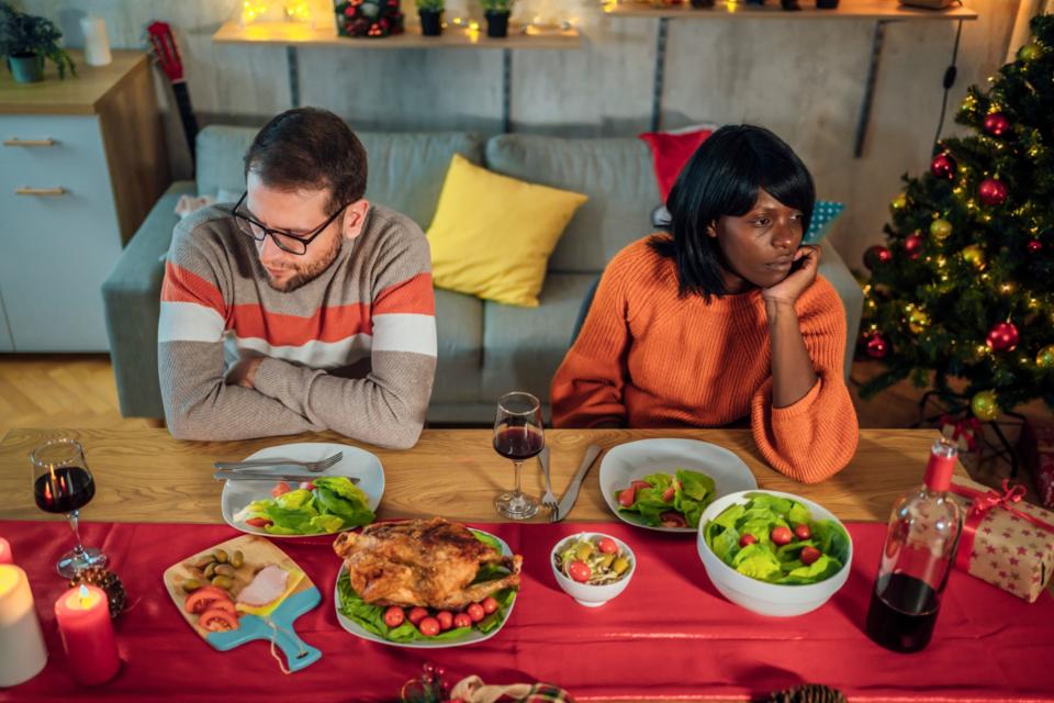 A couple ignoring each other at Christmas Dinner