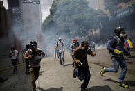 Demonstrators run away while clashing with riot security forces during a rally against President Nicolas Maduro in Caracas, Venezuela May 24, 2017. REUTERS/Carlos Barria