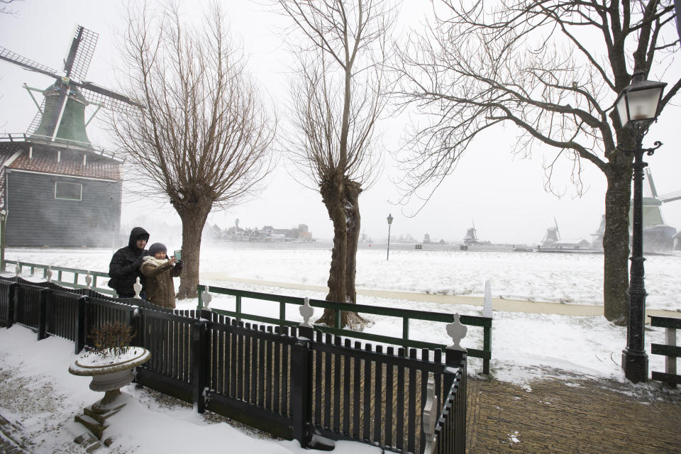 People take a selfie at the Zaans Museum in Zaandam, as snow and strong winds pounded The Netherlands, Sunday, Feb. 7, 2021. (AP Photo/Peter Dejong)