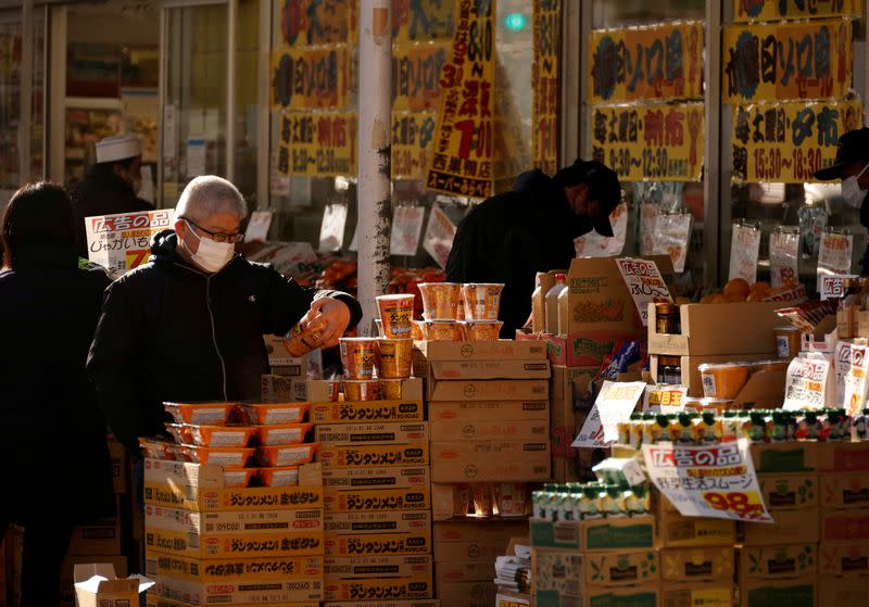 FILE PHOTO: Shoppers check foods at a supermarket in Tokyo