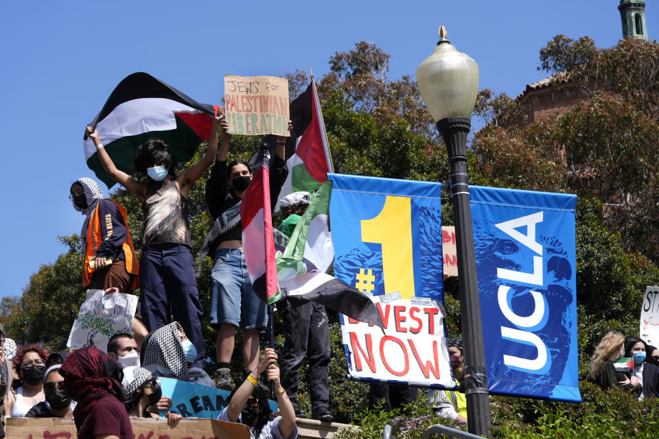 Manifestantes muestran pancartas y ondean banderas en el campus de la Universidad de California en Los Ángeles después de enfrentamientos nocturnos entre grupos propalestinos y proisraelíes, el miércoles 1 de mayo de 2024, en Los Ángeles. (AP Foto/Jae C. Hong)